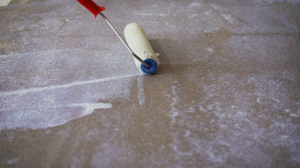applying waterproofing sealant to concrete floor